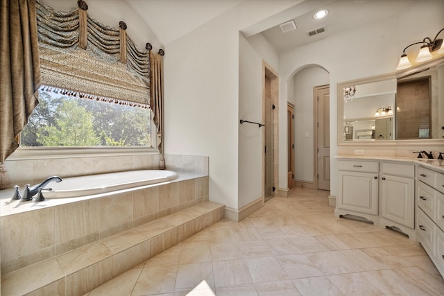 bathroom featuring independent shower and bath, lofted ceiling, vanity, and tile patterned floors