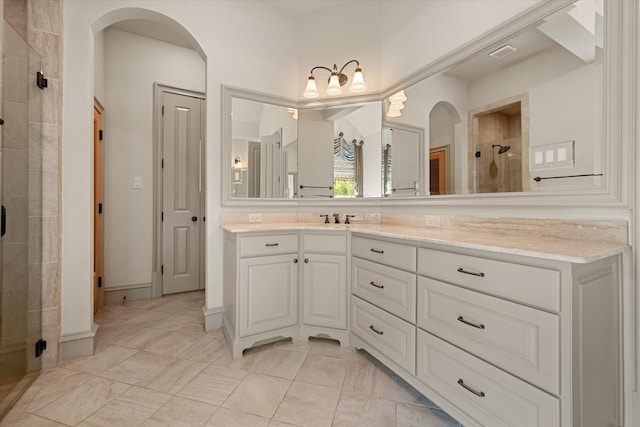 bathroom featuring a shower with door and vanity