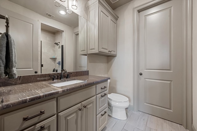 bathroom featuring walk in shower, vanity, and toilet