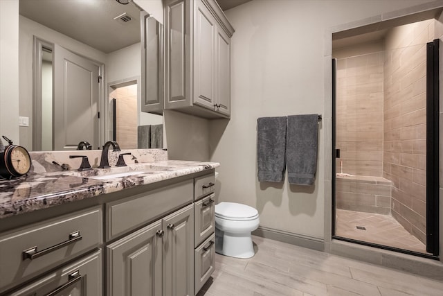 bathroom featuring walk in shower, vanity, and toilet