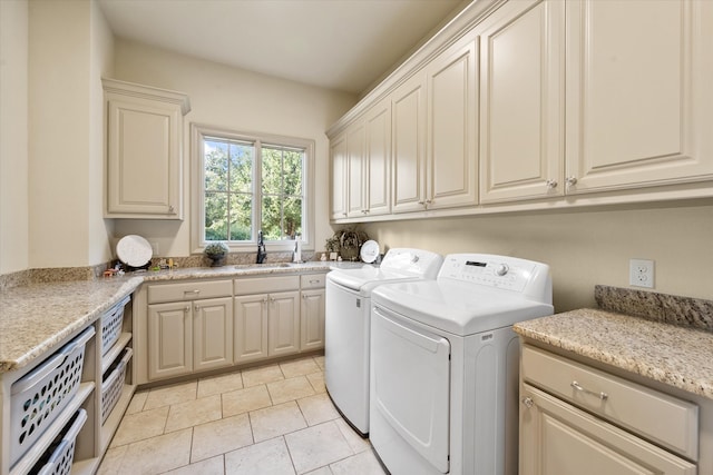 laundry room with washing machine and dryer, light tile patterned flooring, sink, and cabinets