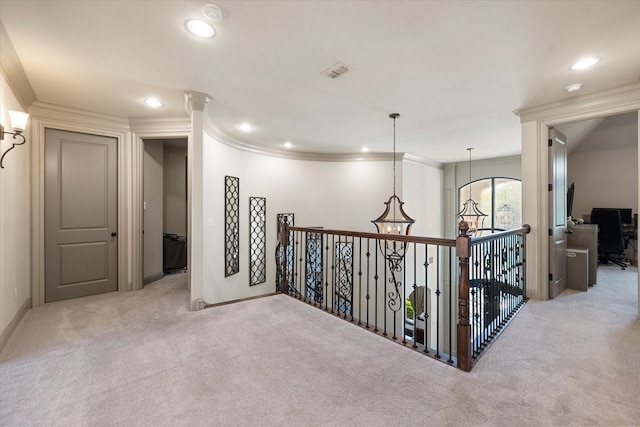 hallway featuring a notable chandelier, light colored carpet, and crown molding