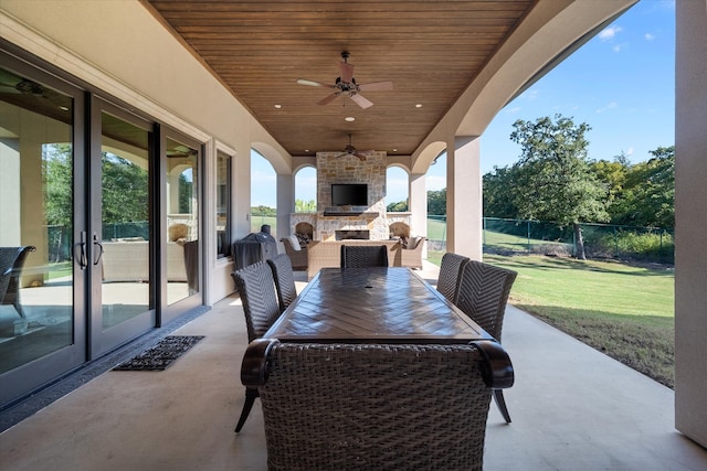 view of patio / terrace featuring ceiling fan and an outdoor stone fireplace