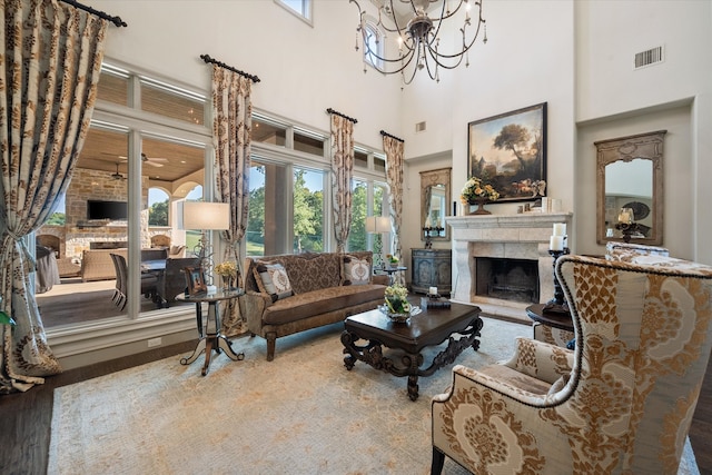 living room with wood-type flooring, a towering ceiling, and a chandelier