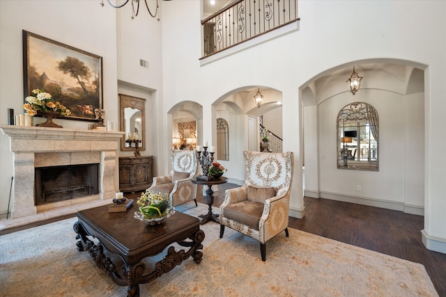 living room with a towering ceiling and dark hardwood / wood-style flooring