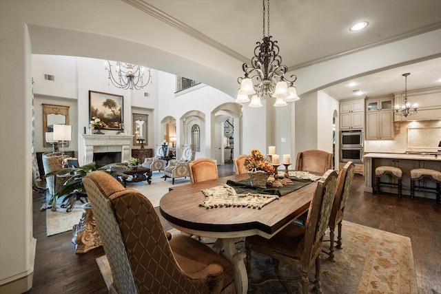 dining space featuring ornamental molding, a tiled fireplace, and dark hardwood / wood-style floors