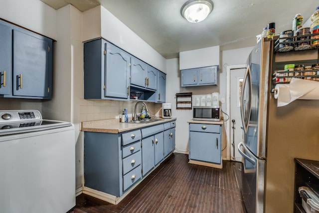 kitchen with washer / dryer, decorative backsplash, stainless steel appliances, sink, and dark hardwood / wood-style flooring