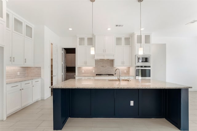 kitchen with a spacious island, stainless steel appliances, hanging light fixtures, and light stone counters