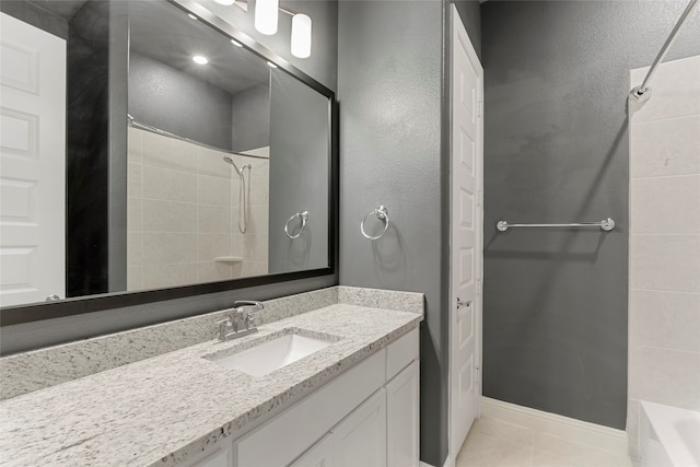 bathroom with tile patterned floors, vanity, and tiled shower / bath