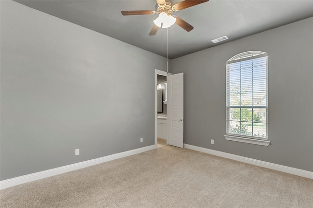 carpeted spare room featuring ceiling fan