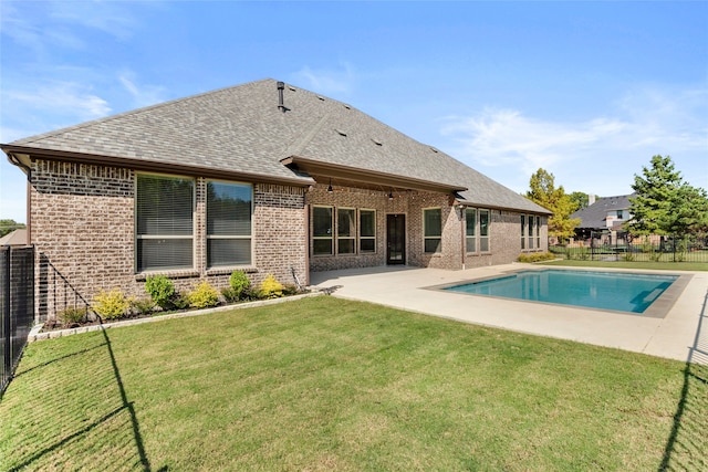 back of house with a fenced in pool, a lawn, and a patio area