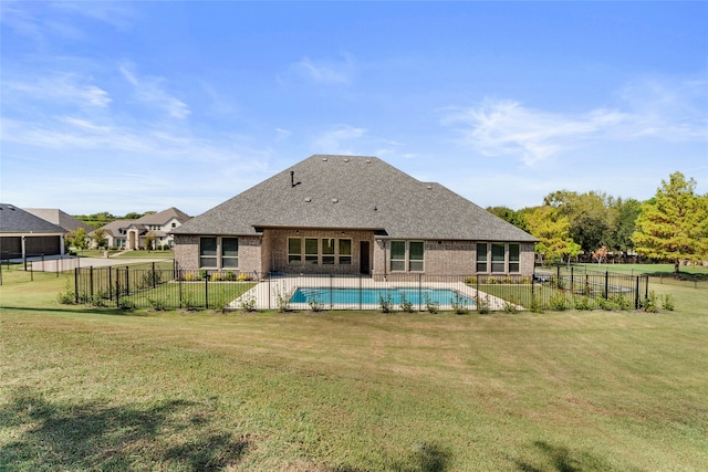 back of house featuring a fenced in pool and a yard