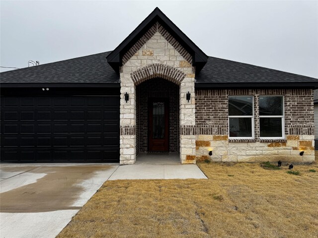 view of front of home with a front yard and a garage