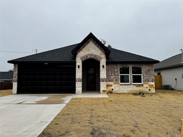 view of front facade featuring a front yard and central AC unit