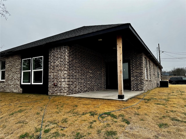 view of side of home featuring a yard and a patio