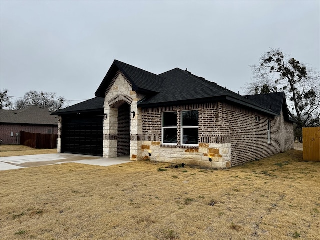 french country style house featuring a garage and a front lawn