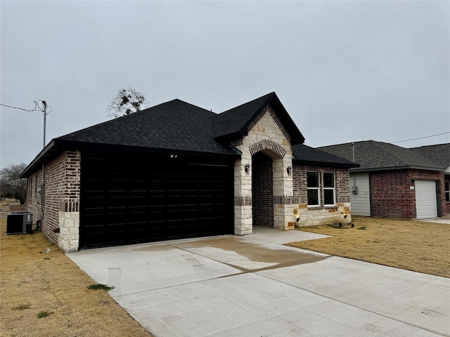 french country inspired facade with a garage, cooling unit, and a front lawn