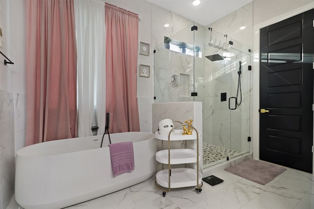 bathroom with shower with separate bathtub and tile walls