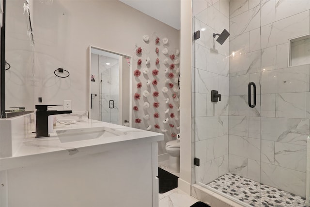 bathroom featuring vanity, toilet, and a shower with door