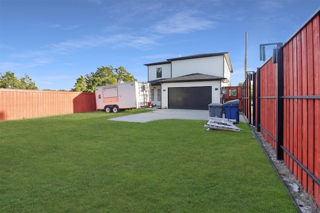 rear view of property with a garage, a lawn, and an outbuilding