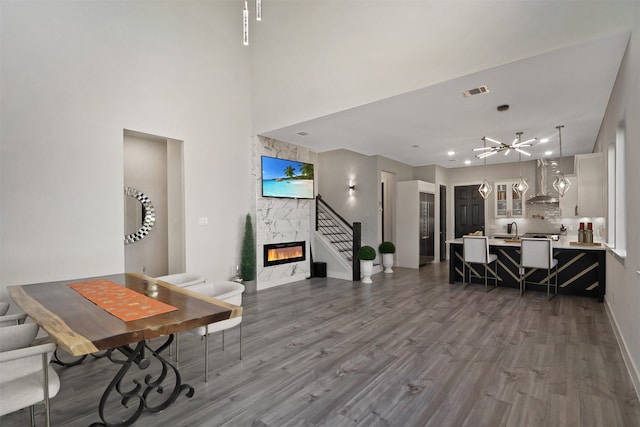 living room featuring a fireplace, an inviting chandelier, dark wood-type flooring, and sink