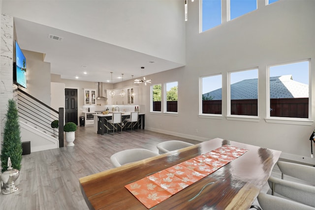 dining room with wood-type flooring, a mountain view, and a high ceiling