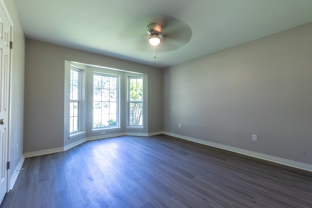 unfurnished room featuring dark hardwood / wood-style floors and ceiling fan