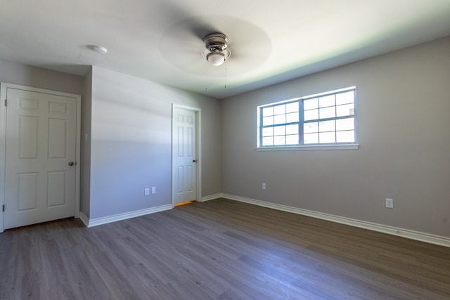 unfurnished bedroom with dark hardwood / wood-style floors and ceiling fan