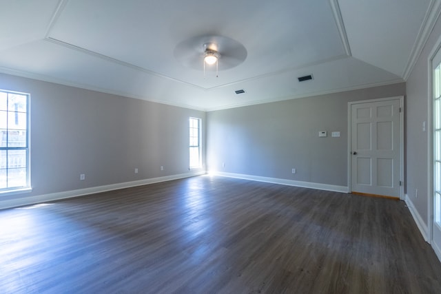 empty room with dark wood-type flooring, ceiling fan, ornamental molding, and a raised ceiling