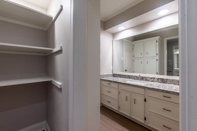 bathroom featuring vanity, ornamental molding, and hardwood / wood-style floors