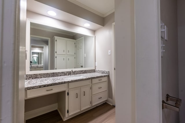 bathroom with crown molding, wood-type flooring, and vanity