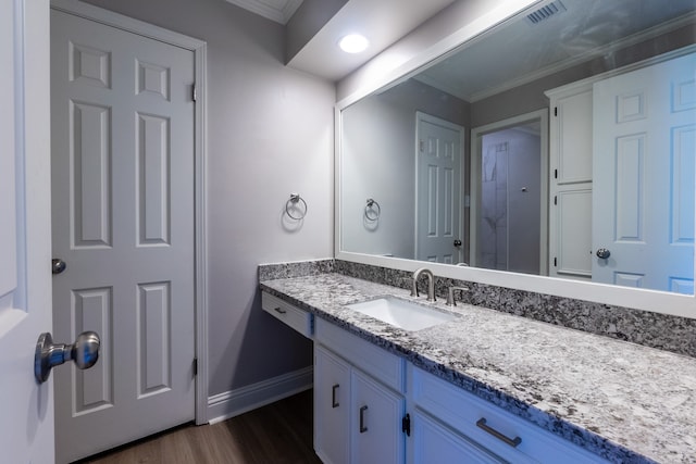 bathroom featuring crown molding, vanity, and hardwood / wood-style flooring