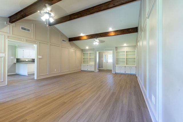 unfurnished living room with lofted ceiling with beams, ceiling fan, light wood-type flooring, and built in shelves