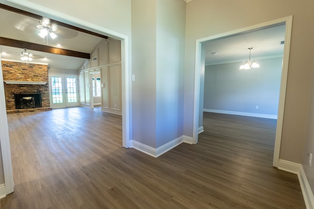 interior space featuring lofted ceiling with beams, dark hardwood / wood-style floors, ceiling fan with notable chandelier, and a fireplace