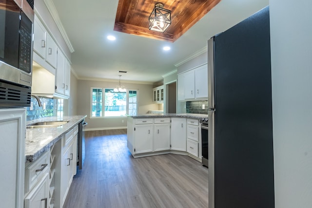 kitchen with stainless steel appliances, white cabinetry, sink, and crown molding