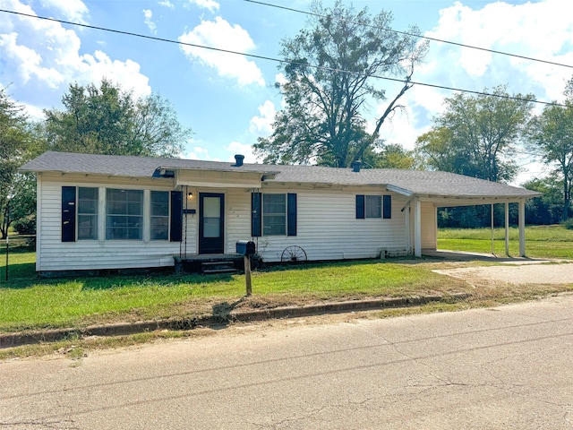 ranch-style house featuring a carport and a front lawn