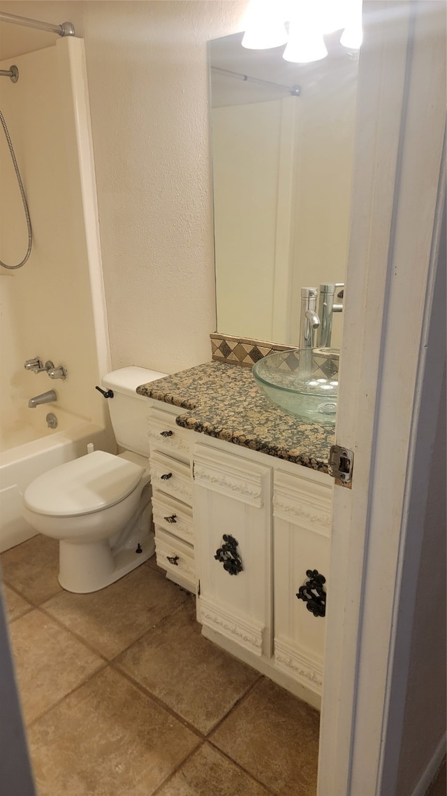 full bathroom featuring washtub / shower combination, tile patterned flooring, vanity, and toilet