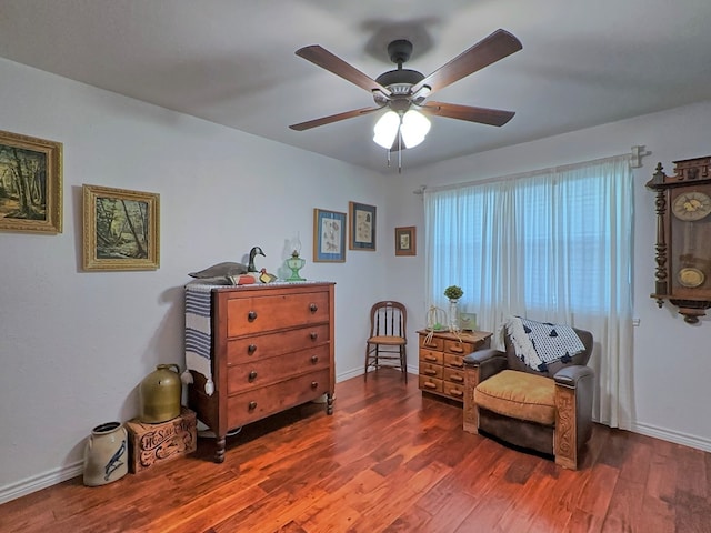 sitting room with ceiling fan and dark hardwood / wood-style floors