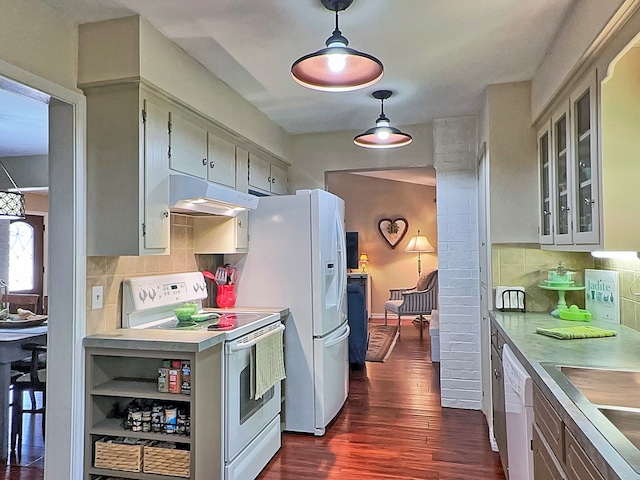 kitchen with white appliances, dark hardwood / wood-style floors, decorative light fixtures, and backsplash