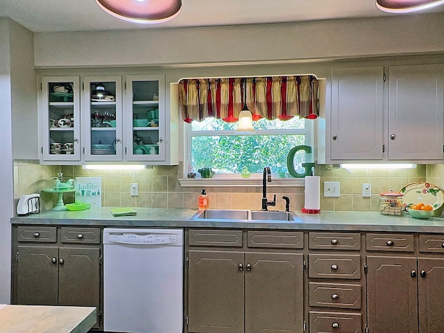 kitchen featuring gray cabinetry, decorative backsplash, dishwasher, and sink