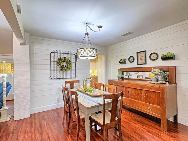 dining space featuring wood walls and hardwood / wood-style flooring