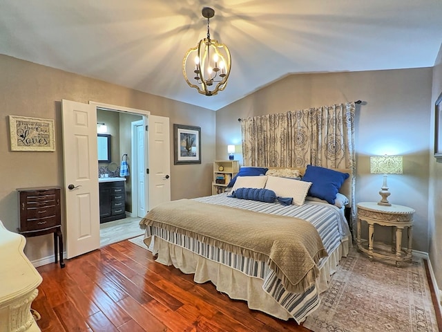 bedroom with vaulted ceiling, hardwood / wood-style floors, ensuite bathroom, and a notable chandelier