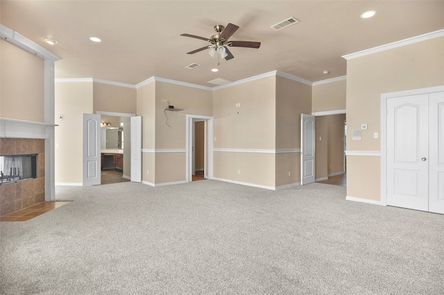 unfurnished living room with ornamental molding, carpet flooring, a fireplace, and ceiling fan