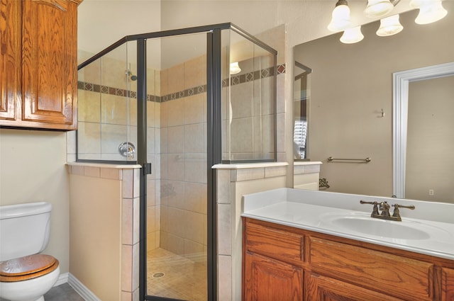 bathroom featuring vanity, toilet, and an enclosed shower