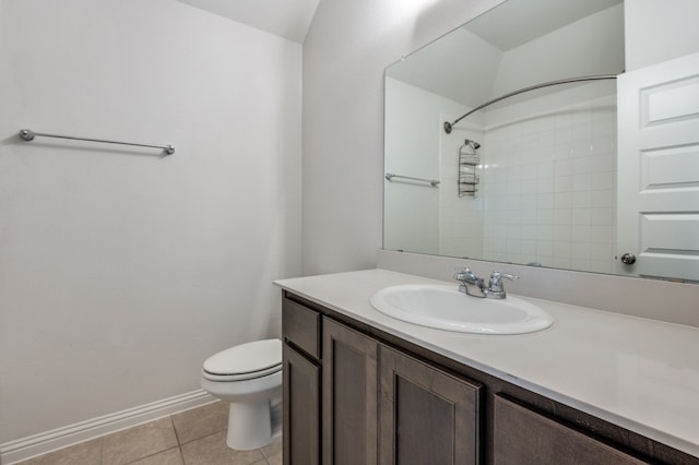 bathroom with a tile shower, tile patterned floors, vanity, and toilet