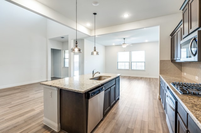 kitchen with appliances with stainless steel finishes, dark brown cabinetry, and sink