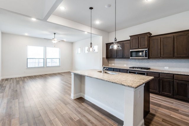 kitchen featuring light stone countertops, hardwood / wood-style flooring, and appliances with stainless steel finishes