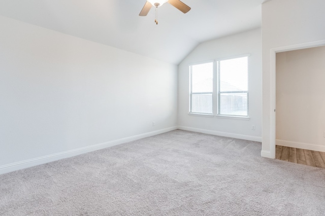 carpeted spare room with lofted ceiling and ceiling fan