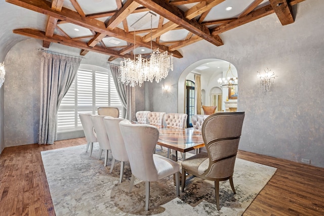 dining space featuring hardwood / wood-style floors, vaulted ceiling with beams, and an inviting chandelier