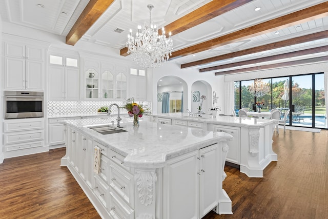 kitchen featuring white cabinets, sink, oven, a kitchen island with sink, and dark hardwood / wood-style floors